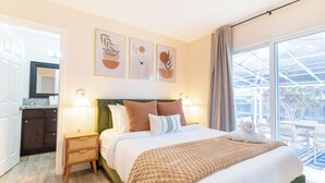 Une chambre d’hôtel avec un grand lit, une table de chevet, un miroir et une vue sur l’extérieur.