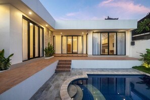 A modern house with a swimming pool, large windows, and a staircase leading to the entrance. - Villa Litan seminyak  (Seminyak)