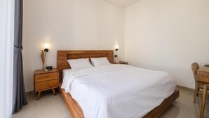 Una camera da letto con un letto di legno, due comodini, una scrivania e una sedia.