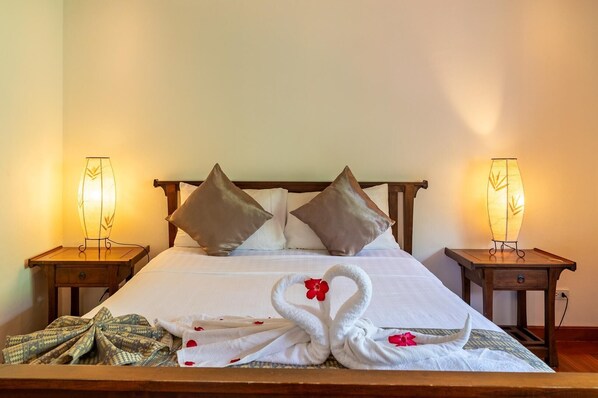 A neatly made bed with two pillows, a bedside table with a lamp, and a towel arrangement on the bed. - 4BR Villa beach walking distance KBR44 (Koh Samui)