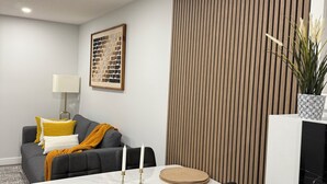 Een moderne eethoek met een witte marmeren tafel, zwarte stoelen en een keukenblad met een spoelbak.