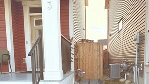 Een woonhuis met een verharde looppad, een houten omheining en een garage.