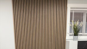 Een moderne eetruimte met een witte marmeren tafel, zwarte lederen stoelen en een houten wandpaneel op de achtergrond.