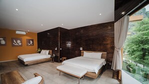 A modern bedroom with two beds, a wooden floor, and a view of greenery outside. - Cendana Trang An Retreat (Hoa Lu)