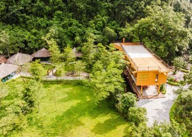 Un centro de retiro rodeado de exuberante vegetación, con un edificio grande identificado como 'CEMUDA TRANGAN RETREAT'.