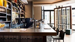 Eine moderne Bar mit Regalen voller Gläser und Flaschen, einer Bar und einer Auslage mit Sonnenbrillen.