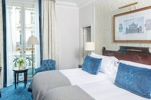 A hotel room with a bed, a chair, a table, a lamp, and a painting on the wall. - InterContinental Paris le Grand (Paris)