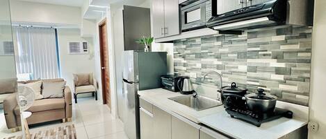 A modern kitchen with a central island, built-in microwave, and stainless steel appliances.