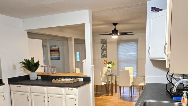 A modern kitchen with white cabinets, a granite countertop, and a central island.