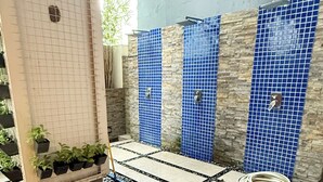A tiled floor with a water feature, stone accents, and potted plants.