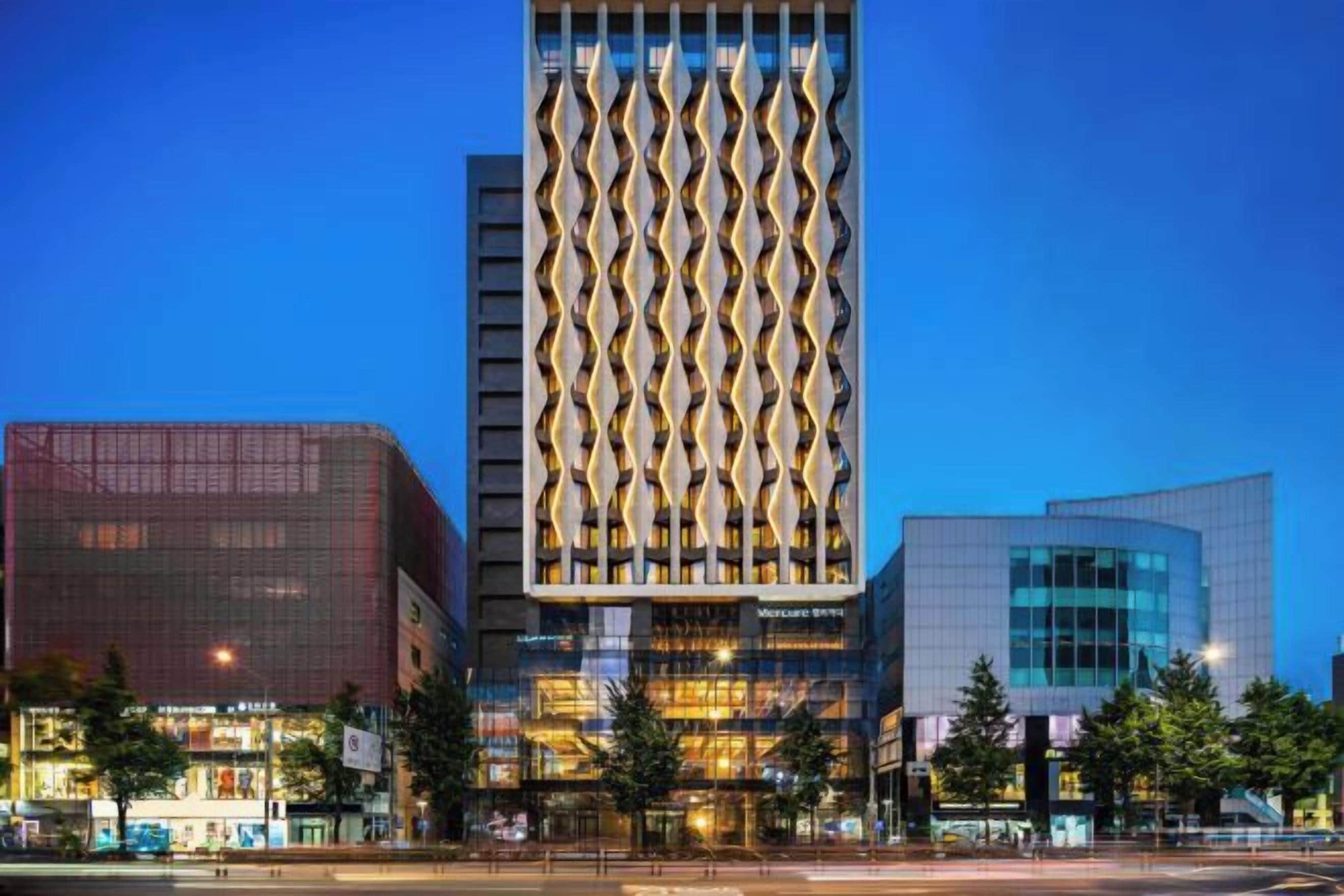 A modern building with a distinctive facade featuring a series of vertical lines and a glass entrance.