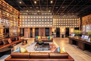 A spacious lobby with a reception desk, seating area, and a patterned wall. - Mercure Ambassador Seoul Hongdae (Seoul)