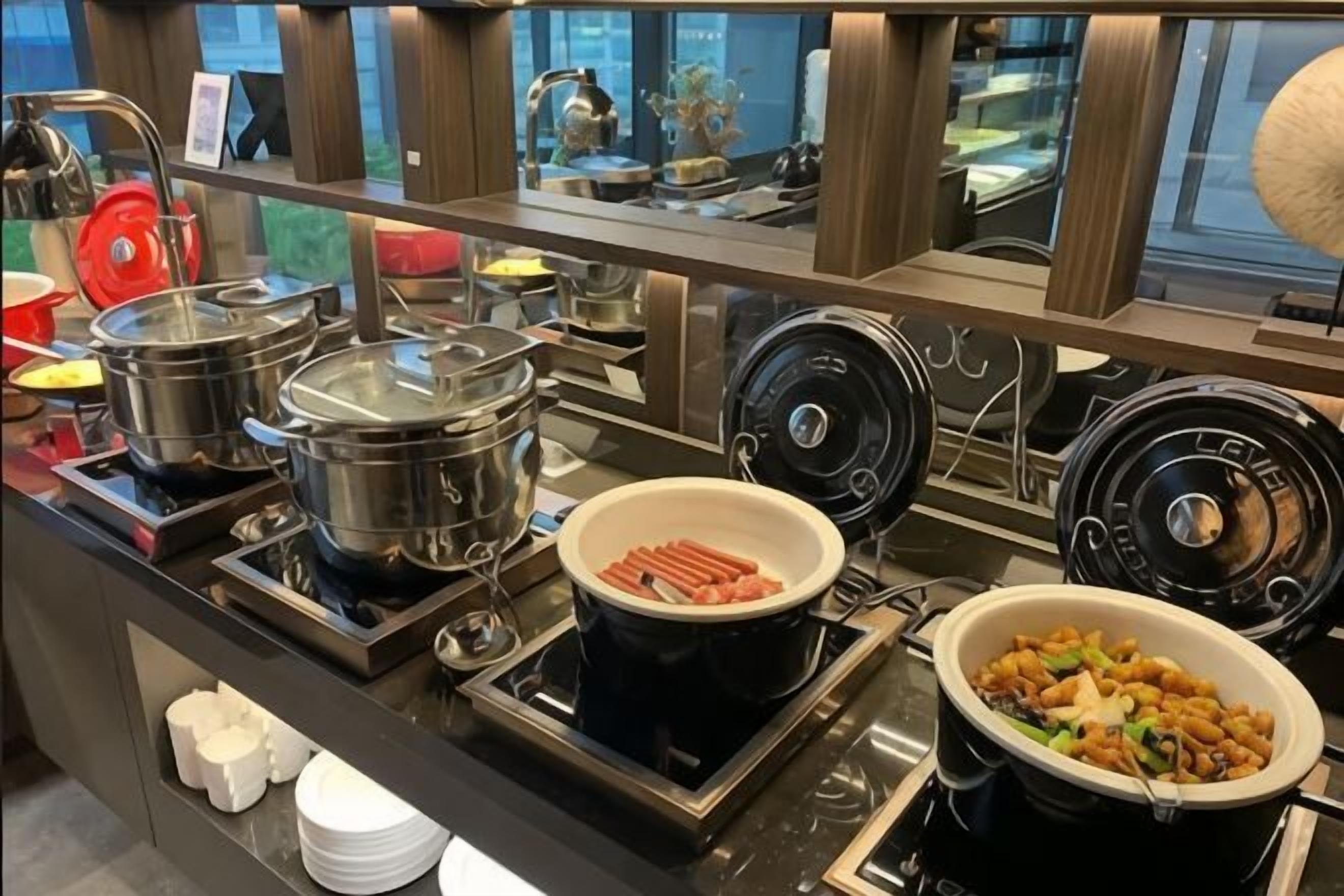 Montaje de bufé con diversos alimentos y equipo de cocina.