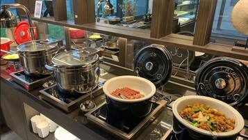 Montaje de bufé con diversos alimentos y equipo de cocina.