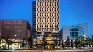 A modern building with a distinctive facade featuring a series of vertical, diamond-shaped patterns.