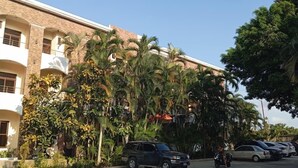 A multi-story building with a parking area in front.