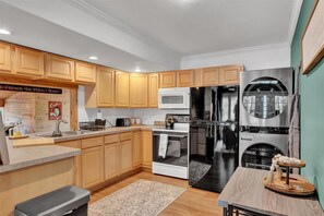 Une cuisine moderne avec des meubles en bois, des appareils en acier inoxydable et un îlot central.