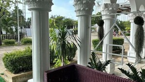 A covered outdoor area with white columns and a bench. - Hawaii Lounge (Sihanoukville)