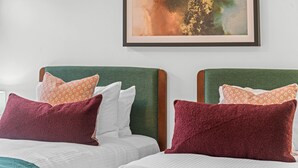 A hotel room with two beds, each with green headboards and patterned pillows. - 2-bed Getaway With Shared Pool & BBQ Access (Brisbane)
