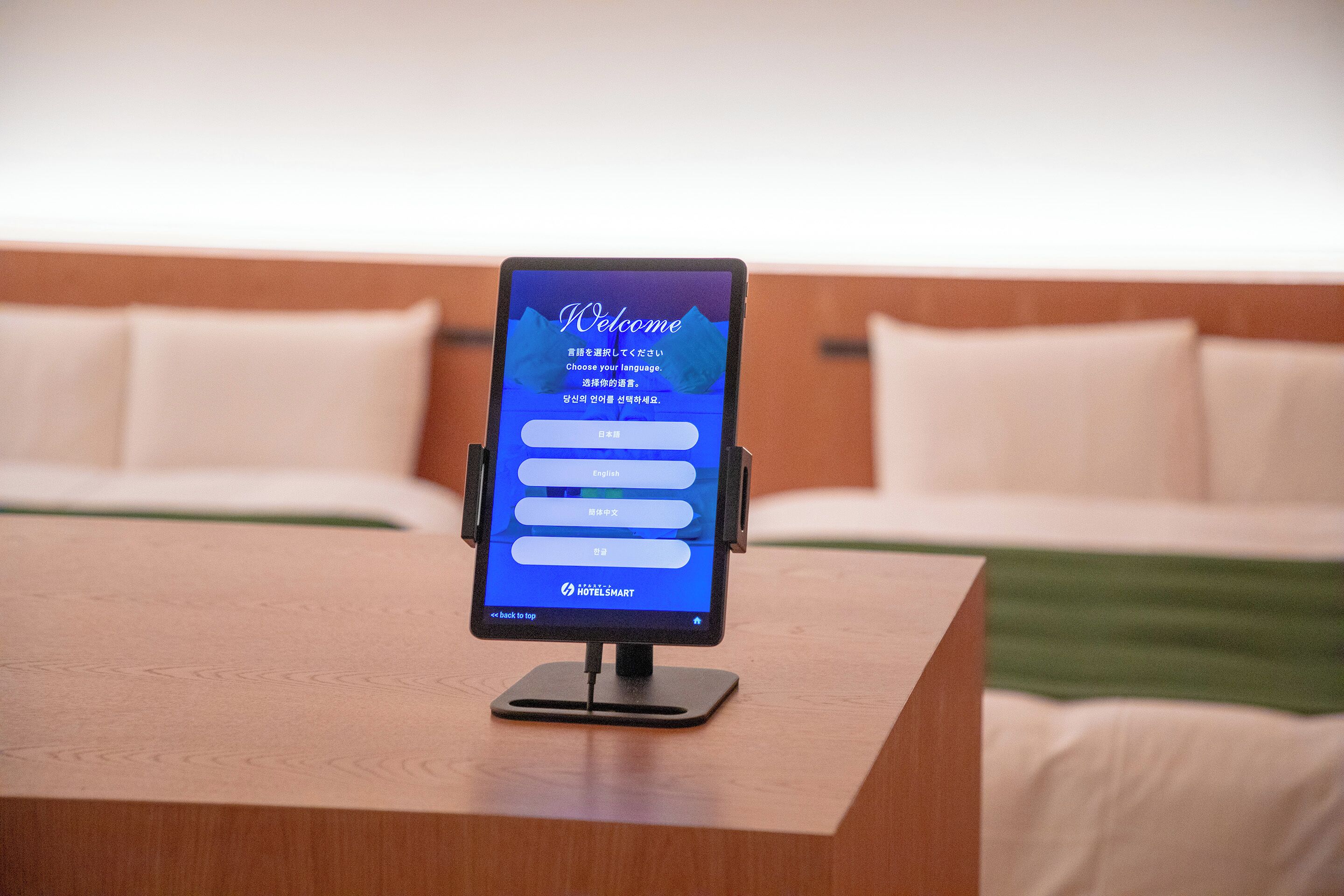 Een hotel receptiebalie met een digitaal scherm dat een menu met taalopties toont.
