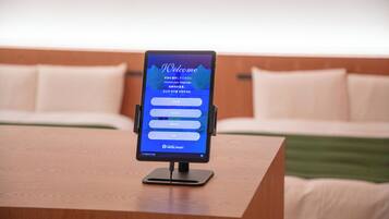 Een hotel receptiebalie met een digitaal scherm dat een menu met taalopties toont.