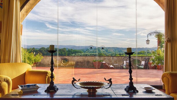 A room with a view of a terrace, featuring a table with decorative items and a sofa. - La Casa degli Archi (Cevoli)