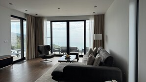 A modern living room with a sofa, armchairs, and a coffee table. Large windows offer a view of the sea. - Cozy accommodation with stunning sea views and everything around is incomparable to see. (Utjeha-Bušat)