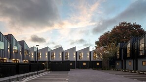 A modern building with a parking lot in front. - Spacious Central Townhouse – Perfect for All (Christchurch)
