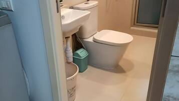 Een douche, handdoeken, zeep, toiletpapier