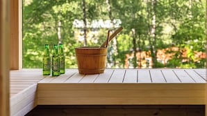A wooden bench with three bottles of Heineken beer and a wooden bucket with a spoon. - Leas Pärla by Interhome (Torup)