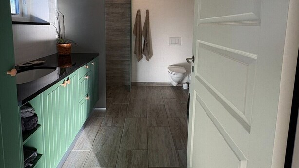 Une salle de bain comprenant des toilettes, un lavabo et un espace douche.