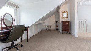 A room with a desk, chair, mirror, dresser, and a small table. - Bright 4-bedroom Maisonette in Gateshead (Gateshead)