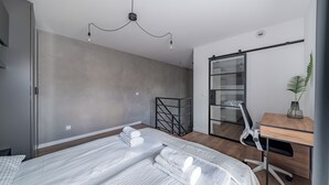 Un dormitorio moderno con una cama, un escritorio y un armario corredero.