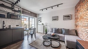 Una cocina moderna con comedor, sofá y pared de ladrillo.