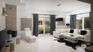 A modern living room with a white sofa, a white armchair, a flat-screen TV, a fireplace, and a large window with curtains. - Villa Piccolo Paradiso with Heated Pool, Jacuzzi & Sauna (Rovinjsko Selo)