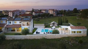A residential area with houses, a swimming pool, and a stone wall. - Villa Piccolo Paradiso with Heated Pool, Jacuzzi & Sauna (Rovinjsko Selo)