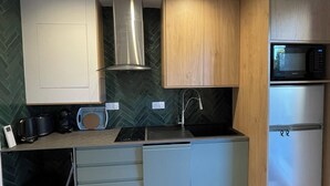 A modern kitchen with a built-in microwave, stainless steel appliances, and wooden cabinets. - L'ESTACADE - CAVALAIRE SUR MER (Cavalaire-sur-Mer)