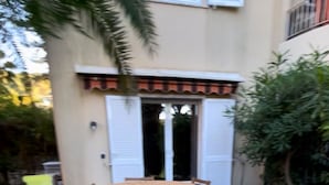 A patio with a round wooden table and four chairs, surrounded by yellow chairs. - L'ESTACADE - CAVALAIRE SUR MER (Cavalaire-sur-Mer)