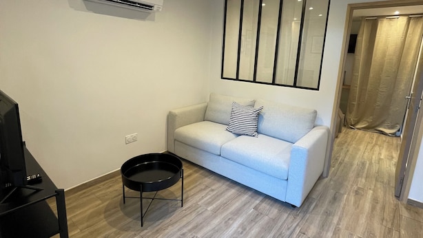 A modern living room with a sofa, a coffee table, and a TV. - L'ESTACADE - CAVALAIRE SUR MER (Cavalaire-sur-Mer)