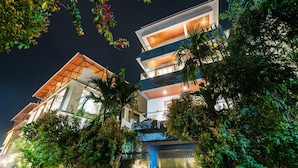A multi-story building with balconies, surrounded by lush greenery. - Dancenter Avanora Villa (Arpora)