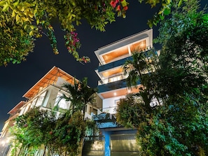 A multi-story building with balconies, surrounded by lush greenery. - Dancenter Avanora Villa (Arpora)