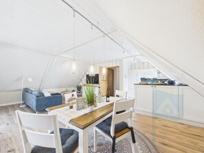 A modern loft apartment with a dining area, kitchen, and living space.