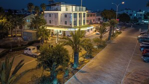 A hotel with a modern design, featuring a prominent sign and a well-lit entrance. - HOLMİ OTEL (Taşucu)