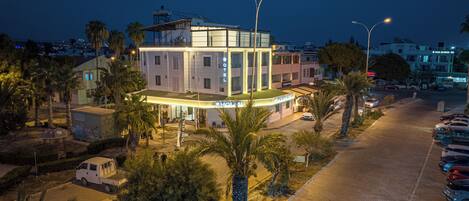 A hotel with a modern design, featuring a prominent sign and a well-lit entrance.