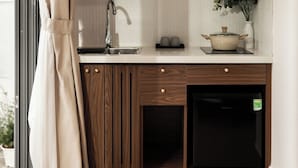 Una cocina moderna con armarios de madera, lavavajillas integrado, un lavabo y una encimera con una planta en maceta.