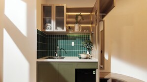 Cocina compacta con lavavajillas integrado, un lavamanos y una encimera con una planta en maceta.