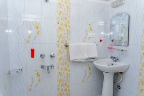 Un baño con lavamanos blanco, espejo y perchero.
