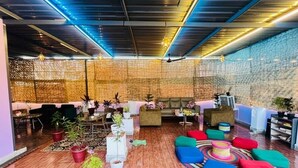 Un espace de détente moderne, doté de sièges, de plantes et d’un mur à texture particulière.