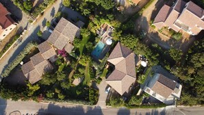 An aerial view of a residential area with multiple houses, a swimming pool, and surrounding greenery. - Mini villa 3 private pool. (Propriano)