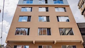 Un edificio de varios pisos con fachada plana y numerosas ventanas.